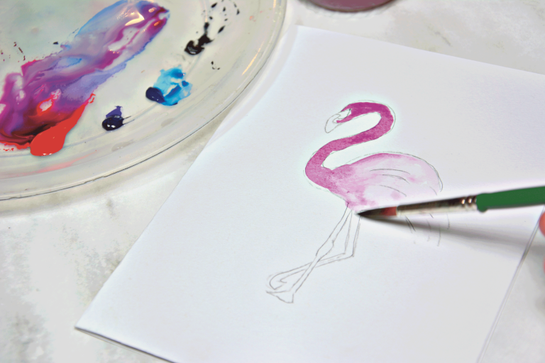Ein Flamingo wird mit Aquarelltinte gemalt.
