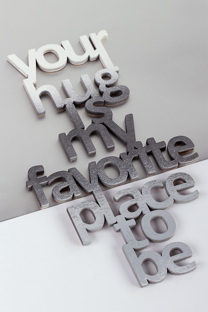 Ein Deko-Holzschild mit dem Spruch Your hug is my favorite place to be"