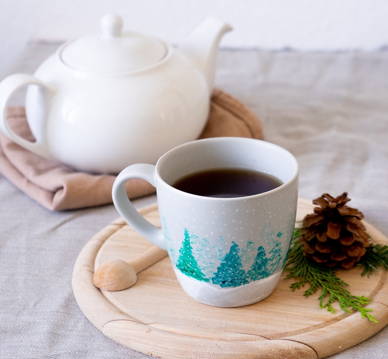 Teekanne und Tasse mit einer Winterlandschaft