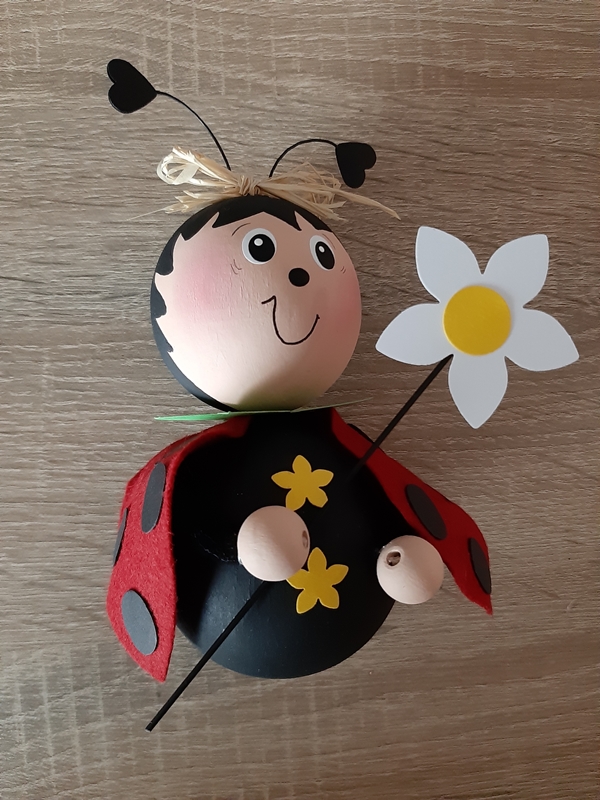 Ein Marienkäfer aus Holzkugeln und Filz