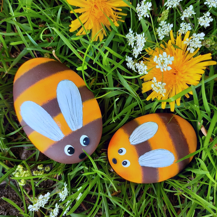 2 Bienen aus bemalten Steinen im Gras