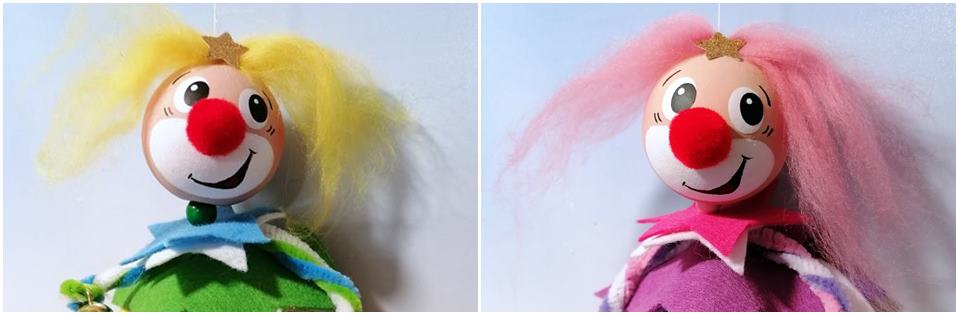 Köpfe von Clowns aus bunten Filzsternen in Rosa- und Blautönen