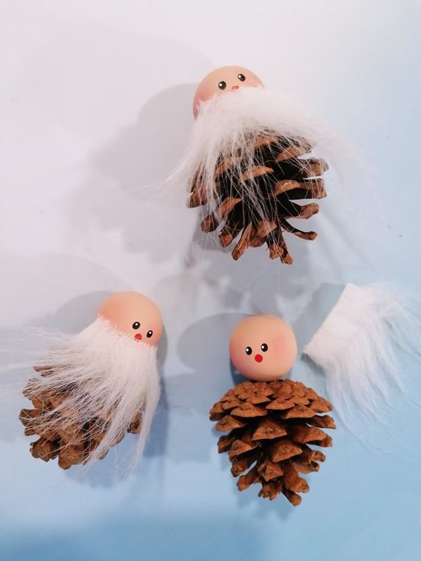 Bärte werden an die Köpfe für die Weihnachtsfiguren geklebt